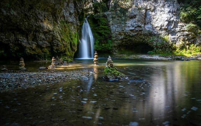 Image of a waterfall and pool with stacked rocks