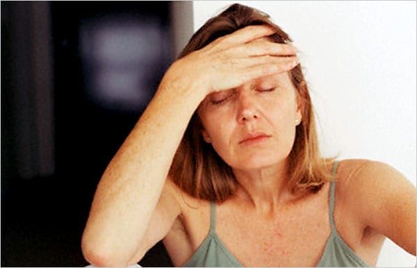 Image of a woman with hand on head
